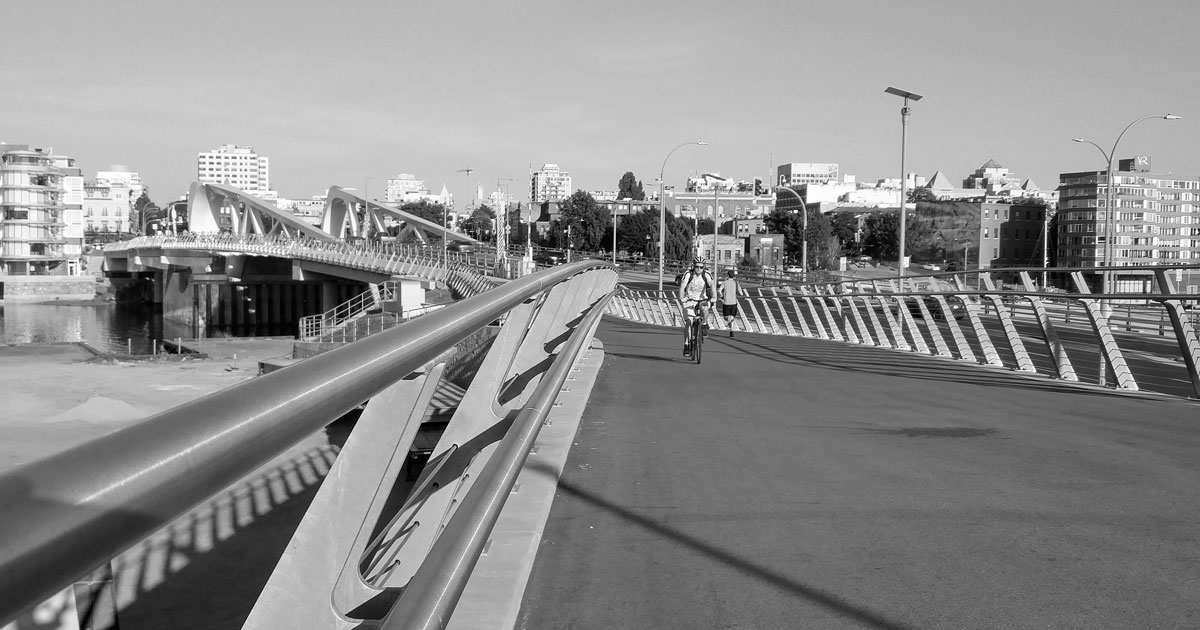 A cyclist rides over the Victoria bridge.